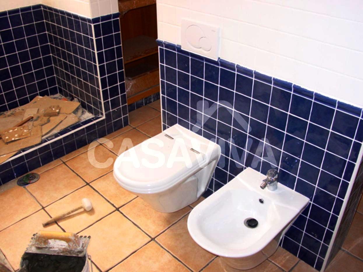 Reforma del cuarto de baño. Nuevas lozas sanitarias suspendidas. Revestimiento de paredes con azulejo cerámico.