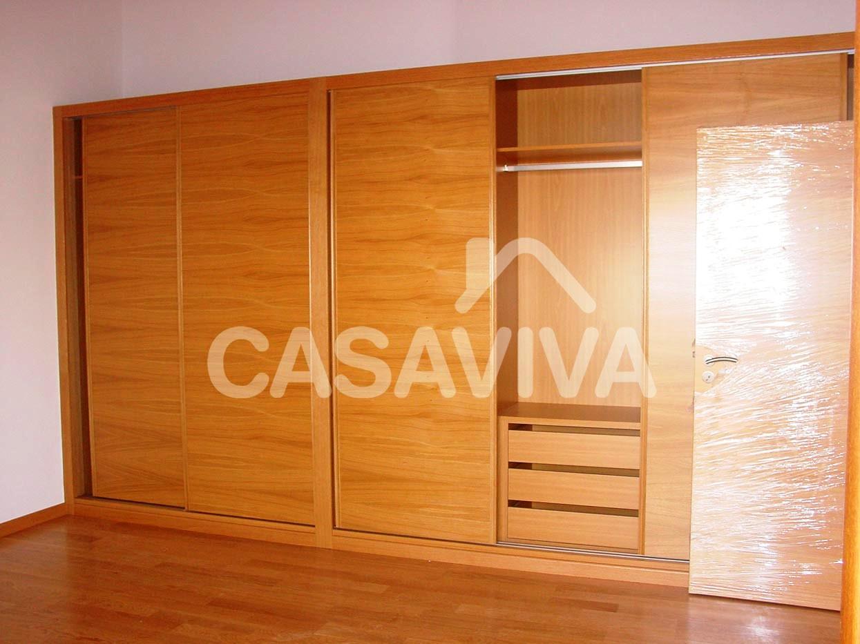 Nuevo armario en madera, empotrado, con puertas correderas y módulos de cajones y estanterías.