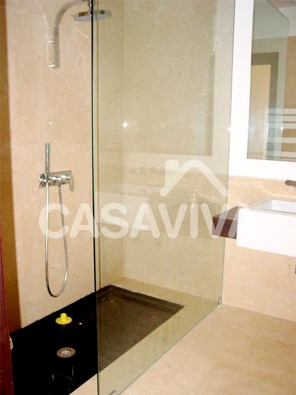 Mueble de baño en madera con lavabo empotrado.Mampara de ducha en vidrio templado.