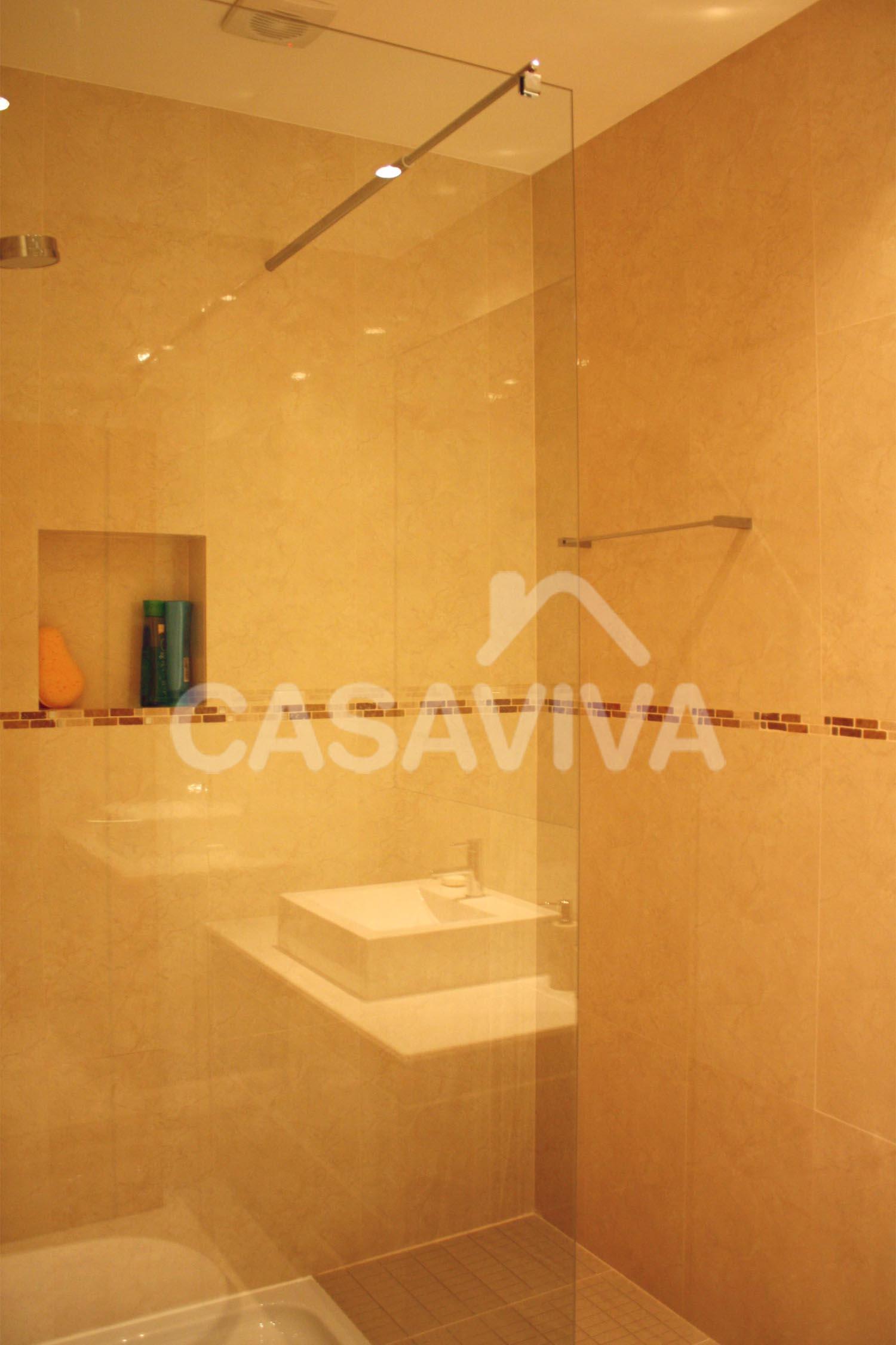 Revestimiento de paredes en azulejo cermico. Plato de ducha con mampara fija en vidrio templado.